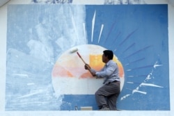 រូបឯកសារ៖ អ្នកគាំទ្រគណបក្សសង្គ្រោះជាតិម្នាក់លាបថ្នាំពី​លើ​ស្លាកសញ្ញាគណបក្សនេះនៅឯទីស្នាក់ការគណបក្សក្នុងរាជធានីភ្នំពេញ ថ្ងៃទី១៨ ខែវិច្ឆិកា ឆ្នាំ២០១៧។