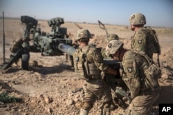 FILE - U.S. soldiers ready a howitzer to be towed into position at Bost Airfield in Afghanistan's Helmand Province in this June 10, 2017, photo provided by Operation Resolute Support.