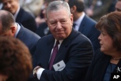 FILE - Former Bush administration Attorney General John Ashcroft is seated before President Barack Obama and FBI Director James Comey arrive at an installation ceremony at FBI Headquarters in Washington, Oct. 28, 2013.