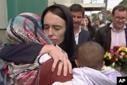 In this image made from video, New Zealand's Prime Minister Jacinda Ardern, center, hugs and consoles a woman as she visited Kilbirnie Mosque to lay flowers among tributes to Christchurch attack victims, in Wellington, March 17, 2019.