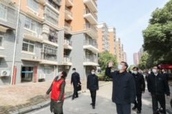 中国国家主席习近平在视察武汉一个居民区时向被隔离的居民招手致意。（2020年3月10日）