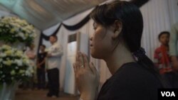 Mourners pray near the body of murdered political analyst and activist Kem Ley. (D. Boyle for VOA)