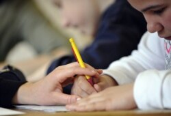 រូបឯកសារ៖ កុមារអូទីហ្សឹមម្នាក់កំពុងរៀនជាមួយគ្រូបង្រៀនជំនាញកម្មវិធីអប់រំពិសេស នៅសាលារៀនមួយក្នុងទីក្រុងប៉ារីស កាលពីថ្ងៃទី ២៤ ខែមេសា ឆ្នាំ ២០០៨។