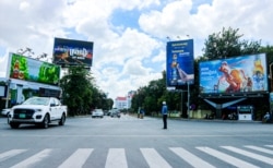 ប៉ូលិសចរាចរណ៍កំពុងធ្វើចរាចរណ៍ត្រង់ចំណុចស្តុបចំការមន ដែលសម្បូរទៅដោយស្លាកផ្សាយពាណិជ្ជកម្មស្រាបៀរ នៅរាជធានីភ្នំពេញ កាលពីថ្ងៃទី២៩ ខែតុលា ឆ្នាំ២០២១។ (កាន់ វិច្ឆិកា/វីអូអេ)