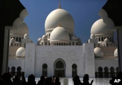Tourists take photographs at the Sheikh Zayed Grand Mosque in Abu Dhabi, United Arab Emirates, on Sunday, Oct. 23, 2016. (AP Photo/Jon Gambrell)