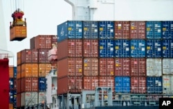 FILE- A container is loaded onto a cargo ship at the Tianjin port in China, Aug. 5, 2010.