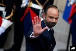 Newly appointed French Prime Minister Edouard Philippe waves after the handover ceremony with outgoing Prime Minister Bernard Cazeneuve in Paris, May, 15, 2017.