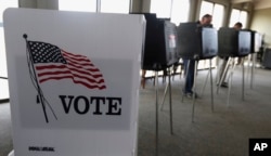 FILE - Voters cast ballots in the Illinois primary in Hinsdale, Ill., March 18, 2014. Illinois' top election officials insist that a recent hack into state voter rolls, which contain the names of 8 million active voters, does not pose a threat to the Nov.