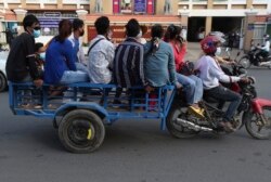 កម្មករធ្វើដំណើរតាមម៉ូតូអូសរទេះកាត់សាលាដំបូងរាជធានីភ្នំពេញ កាលពីថ្ងៃទី ១៨ ខែសីហា ឆ្នាំ ២០២១។