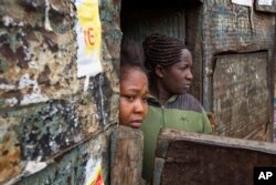 Residents watch Kenyan security forces chase supporters of Kenyan opposition leader and presidential candidate Raila Odinga who demonstrate in the Mathare area of Nairobi, Aug. 9, 2017.