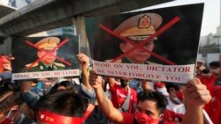 Burmese living in Thailand hold pictures of Myanmar military Commander-in-Chief Senior Gen. Min Aung Hlaing during a protest in front of the Myanmar Embassy, in Bangkok, Thailand, Monday, Feb. 1, 2021.