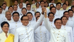 រូបឯកសារ៖ លោក សម រង្ស៊ី (ឆ្វេង) និង​លោក កឹម សុខា (ស្ដាំ) ឈរ​ចាប់​ដៃ​គ្នា​នៅ​មុខ​សមាជិក​សភា មុន​ពេល​ពិធី​ស្បថ​ចូល​កាន់​តំណែង​នៅ​ខាង​ក្នុង​ព្រះ​បរម​រាជវាំង រាជធានី​ភ្នំពេញ ថ្ងៃទី៥ ខែសីហា ឆ្នាំ២០១៤។