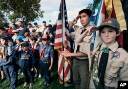 FILE - Boy Scouts and Cub Scouts salute the flag during ceremonies at the Los Angeles National Cemetery in Los Angeles, May 26, 2018.