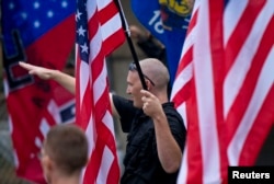 FILE - A member of a white supremacy group gives a salute during a gathering in West Allis, Wisconsin, Sept. 3, 2011.