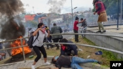 A protester lies on the ground as demonstrators are dispersed away from the national assembly by riot police, in Quito on October 8, 2019.