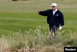 Predsednik SAD Donald Tramp gestikulira dok hoda tokom odmora na golf terenu u Turnberiju, Škotska, 14. jula 2018.