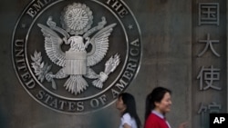 Chinese women walk into the visa application section of the U.S. Embassy in Beijing Friday, May 31, 2013. (AP Photo/Andy Wong)