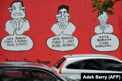 Sebuah mural bertuliskan "Saya Bangga Punya Tiga Rumah Mewah (Kiri), Saya Bangga Punya Lima Mobil Mewah (C), Saya Bangga Tidak Melakukan Korupsi", di dinding sebuah jalan di Jakarta pada tanggal 18 November 2009 .(Foto: AFP/Adek Berry)