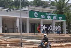 រូប​ឯកសារ៖ បុរស​ម្នាក់​បើក​ម៉ូតូ​កាត់​ផ្សារទំនើប​របស់​ចិន ដែល​ស្ថិត​នៅ​ព្រំដែន​កម្ពុជា​ថៃ​ក្នុង​ខេត្តកោះកុង។ (ស៊ុន ណារិន/VOA)