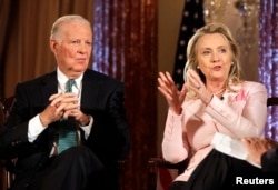 FILE - Then-Secretary of State Hillary Clinton speaks next to former Secretary of State James Baker during a "Conversation on Diplomacy" at the State Department in Washington, June 20, 2012.
