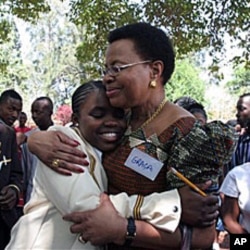Graca Machel, wife to former South African president Nelson Mandela, centre right, hugs Charelen Vhuta, during her visit to Harare, Zimbabwe, 16 Nov 2010