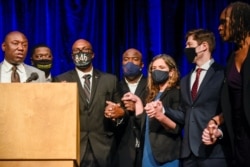 Pengacara keluarga Floyd Ben Crump, paling kiri, bergandengan tangan dengan anggota keluarga George Floyd dan pejabat kota dalam konferensi pers masalah penyelesaian $27 juta dengan Kota Minneapolis, 12 Maret 2021. (Foto: REUTERS/Nicholas Pfos