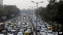 FILE - Vehicles move slowly at a traffic intersection after the end of a two-week experiment to reduce the number of cars to fight pollution in in New Delhi, India, Jan. 16, 2016.