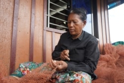 Teav Savath, 59, fixes the fishing nets for her younger nieces and nephews who go fishing and feed the whole family, in Battambang province, on September 26, 2021. (Khan Sokummono/VOA Khmer)