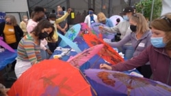 AFS exchange students and volunteers paint colors on paper umbrellas at a demonstrated workshop during a day-long tour of Thai Town hosted by the Thai Town Council Of Los Angeles in Los Angeles, CA.