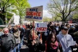 FILE - Two women with posters attend with thousands of demonstrators the March for Science in Berlin, April 22, 2017.