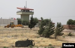 Beberapa tentara Turki berjaga di sebuah pos pengamatan di penyeberangan Atmeh di perbatasan Turki-Suriah, tampak dari Provinsi Idlib, Suriah, 31 Mei 2019. (Foto: Khalil Ashawi/Reuters)