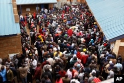 Voters line up early morning in cold weather at a polling station in the Kibera Slums in Nairobi, Kenya, Aug. 8, 2017.