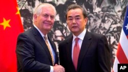El secretario de Estado estadounidense, Rex Tillerson, y el ministro de Relaciones Exteriores de China, Wang Yi, se estrechan las manos al final de una conferencia de prensa conjunta tras su reunión en la pensión estatal Diaoyutai en Beijing, China.