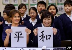 Las primeras damas de EE.UU. y Japón muestran su trabajo en caligrafía japonesa durante una visita a una escuela primaria de Tokio. Nov. 6 de 2017.