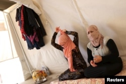 Yazidi sisters, who escaped from captivity by Islamic State (IS) militants, sit in a tent at Sharya refugee camp on the outskirts of Duhok province, Iraq, July 3, 2015. The sisters were among the thousands of women, men and children taken by IS as prisoners.
