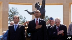 Predsjednik Barack Obama i francuski predsjednik Francois Hollande stoje sa veteranima na američkom groblju Normandy na plaži Omaha u Colleville sur Mer, Normandija, Francuska, 6. juna 2014.