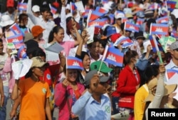 រូបឯកសារ៖ កម្មករ​រោងចក្រកម្ពុជា​ស្រែកហូ និង​ក្រវីទង់ជាតិ​ខ្មែរ នៅ​ពេល​ដែល​ពួក​គេ​ចូលរួម​ក្នុង​បាតុកម្ម​មួយ ដើម្បី​អំពាវនាវឲ្យ​រដ្ឋាភិបាល​តម្លើង​ប្រាក់​បៀរវត្សរ៍​ក្នុង​ក្បួន​ដង្ហែរ​ថ្ងៃទិវាពលកម្ម​អន្តរជាតិ​នៅ​ទីក្រុងភ្នំពេញ ថ្ងៃទី១ ខែ​ឧសភា ឆ្នាំ២០១៥។ (REUTERS/Pring Samrang)