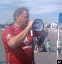 AmpSurf founder Dana Cummings commands the beach with his megaphone as he welcomes participants to a surfing class in Maine.