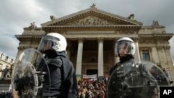 Police in riot gear protect one of the memorials to the victims of the recent Brussels attacks
