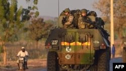 French army soldiers stand on armored vehicles as they leave Bamako and start their deployment to the north of Mali as part of the "Serval" operations, January 15, 2013.