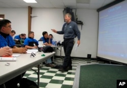 In this June 30, 2009 file photo, Larry Wostenberg teaches an engine management systems class at the WyoTech technical school, which was operated by Corinthian Colleges Inc, at their campus in Laramie, Wyoming