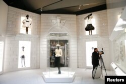 A person photographs creations during a photocall for the "Christian Dior: Designer of Dreams" exhibition at the Victoria & Albert (V&A) Museum in London, Jan. 30, 2019.