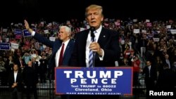 Republican U.S. presidential nominee Donald Trump (R) and vice presidential candidate Mike Pence (L) hold a campaign rally in Cleveland, Oct. 22, 2016.
