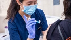 A healthcare worker administers a dose of the COVID-19 vaccine at Kheir Center, Los Angeles.CA