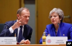 British Prime Minister Theresa May and European Council President Donald Tusk attend a round table meeting at an EU summit in Brussels, Nov. 25, 2018.