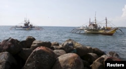 FILE - Filipino fishing boats that were sprayed with water by Chinese Coastguard are pictured while anchored at shorelines of the coastal town of Infanta, Pangasinan in northern Philippines, April 22, 2015.
