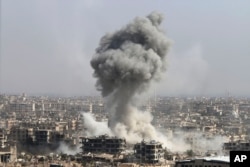 FILE - Smoke rises after shelling by the Syrian army, after Russian airstrikes, in Damascus, Syria, Oct. 14, 2015.