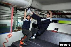 Employees assemble a bus at the production line of Foton Motor Corporation in Beijing, China, June 16, 2009.