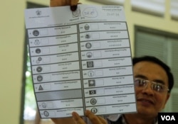 មន្ត្រីរៀបចំការបោះឆ្នោតលើកបង្ហាញសន្លឹកឆ្នោតមួយសន្លឹក បន្ទាប់ពីការិយាល័យ​បោះឆ្នោតនៅទូទាំងប្រទេសបានបិទ នៅសង្កាត់បឹងកេង​កង២ ខណ្ឌ​ចំការមន រាជធានីភ្នំពេញ​ នៅ​ថ្ងៃអាទិត្យ​ ទី២៩ ខែកក្កដា​ ឆ្នាំ២០១៨។ (ខាន់ សុគុំមនោ/VOA)