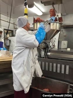 Nick Holubyckyj puts raw beef into the machine for compression and into bags.